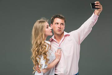 Image showing Portrait of a young couple standing against gray background