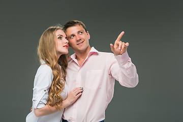 Image showing Portrait of a young couple standing against gray background