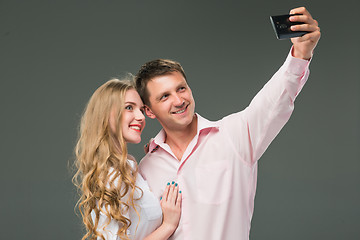 Image showing Portrait of a young couple standing against gray background