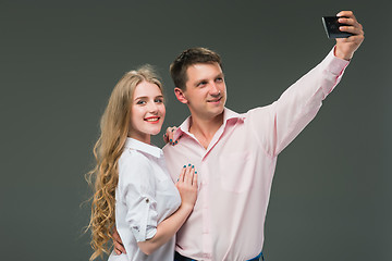 Image showing Portrait of a young couple standing against gray background