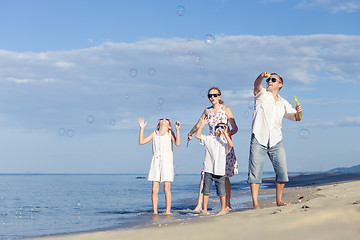 Image showing Happy family walking on the beach at the day time.