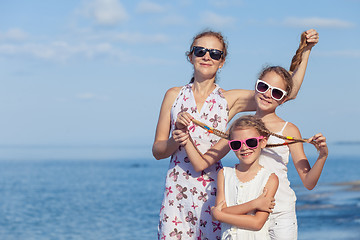 Image showing Mother and children playing on the beach at the day time.