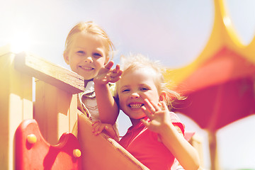 Image showing happy girls waving hands on children playground