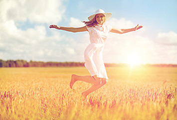 Image showing happy young woman jumping on cereal field