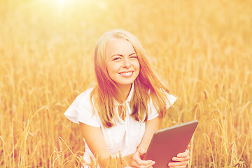 Image showing happy young woman with tablet pc on cereal field