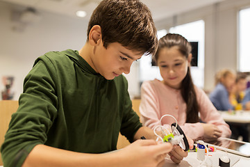 Image showing happy children building robots at robotics school