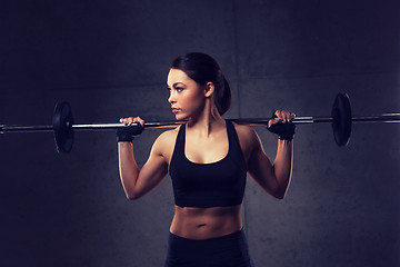 Image showing young woman flexing muscles with barbell in gym