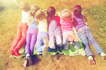 Image showing group of kids lying on blanket or cover outdoors