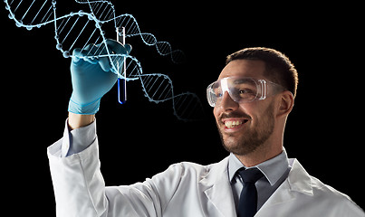 Image showing smiling scientist in safety glasses with test tube