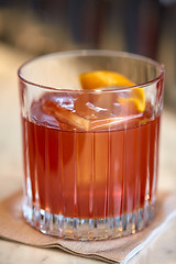 Image showing close up of glass with orange cocktail at bar