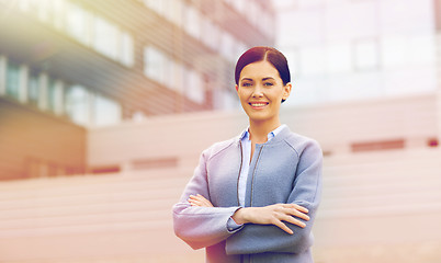 Image showing young smiling businesswoman over office building