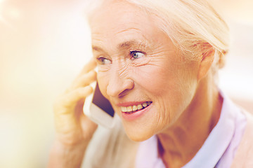 Image showing senior woman with smartphone calling at home