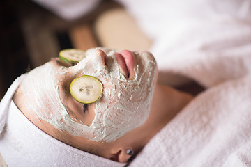 Image showing woman is getting facial clay mask at spa