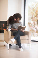 Image showing multiethnic couple hugging in front of fireplace