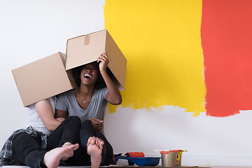 Image showing young multiethnic couple playing with cardboard boxes