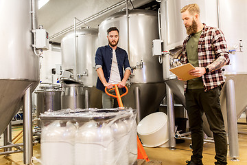 Image showing men with malt and clipboard at craft beer brewery