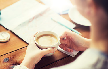 Image showing close up of hands with coffee cup and travel stuff