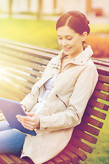 Image showing woman with tablet pc sitting on bench in park