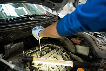 Image showing mechanic man with wrench repairing car at workshop