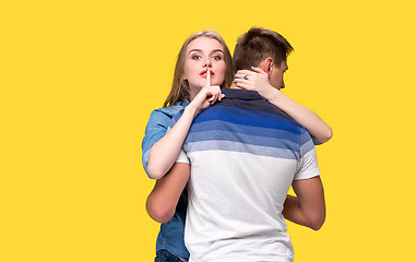 Image showing Portrait of a young couple standing against yellow background