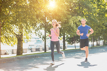 Image showing The sporty woman and man jogging at park in sunrise light