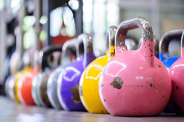 Image showing colorful kettlebells in a row in a gym