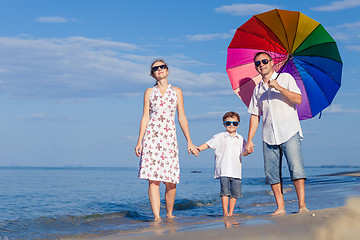 Image showing Happy family walking on the beach at the day time.