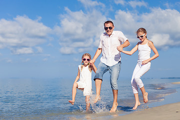 Image showing Father and children playing on the beach at the day time.