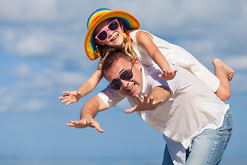 Image showing Father and daughter playing on the beach at the day time.
