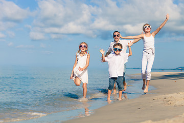 Image showing Father and children playing on the beach at the day time.