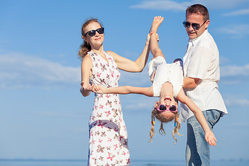 Image showing Happy family walking on the beach at the day time.