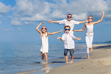 Image showing Father and children playing on the beach at the day time.