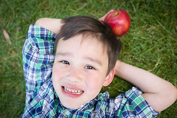 Image showing Mixed Race Chinese and Caucasian Young Boy With Apple Relaxing O