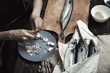 Image showing Woman preparing mackerel fish