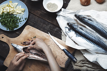 Image showing Woman preparing mackerel fish