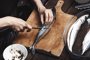Image showing Woman preparing mackerel fish