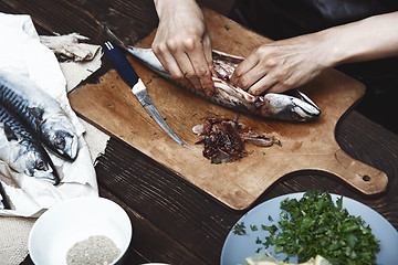 Image showing Woman preparing mackerel fish