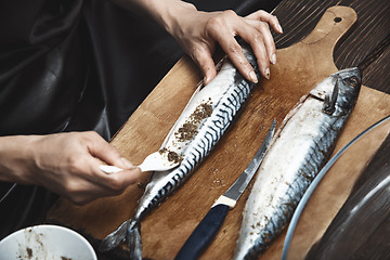 Image showing Woman preparing mackerel fish