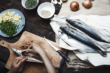 Image showing Woman preparing mackerel fish