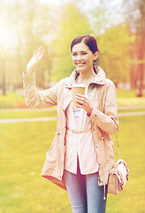 Image showing smiling woman drinking coffee in park