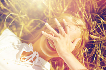 Image showing happy young woman lying on cereal field