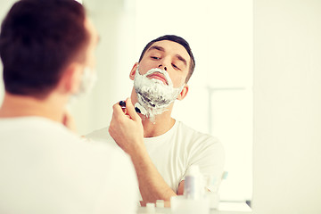 Image showing man shaving beard with razor blade at bathroom