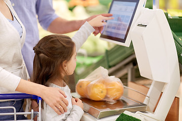 Image showing family weighing oranges on scale at grocery store