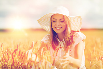 Image showing happy young woman in sun hat on cereal field