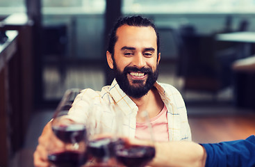 Image showing happy man clinking glass of wine at restaurant