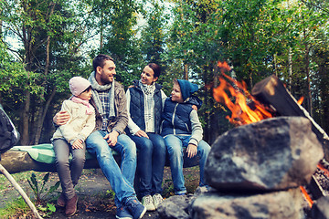 Image showing happy family sitting on bench at camp fire