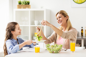 Image showing happy family eating salad at home kitchen