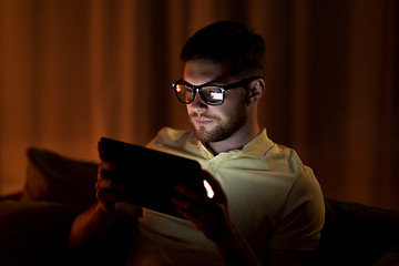Image showing young man with tablet pc networking at night