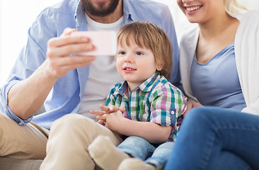 Image showing happy family with smartphone at home