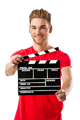 Image showing Young man holding a clapboard